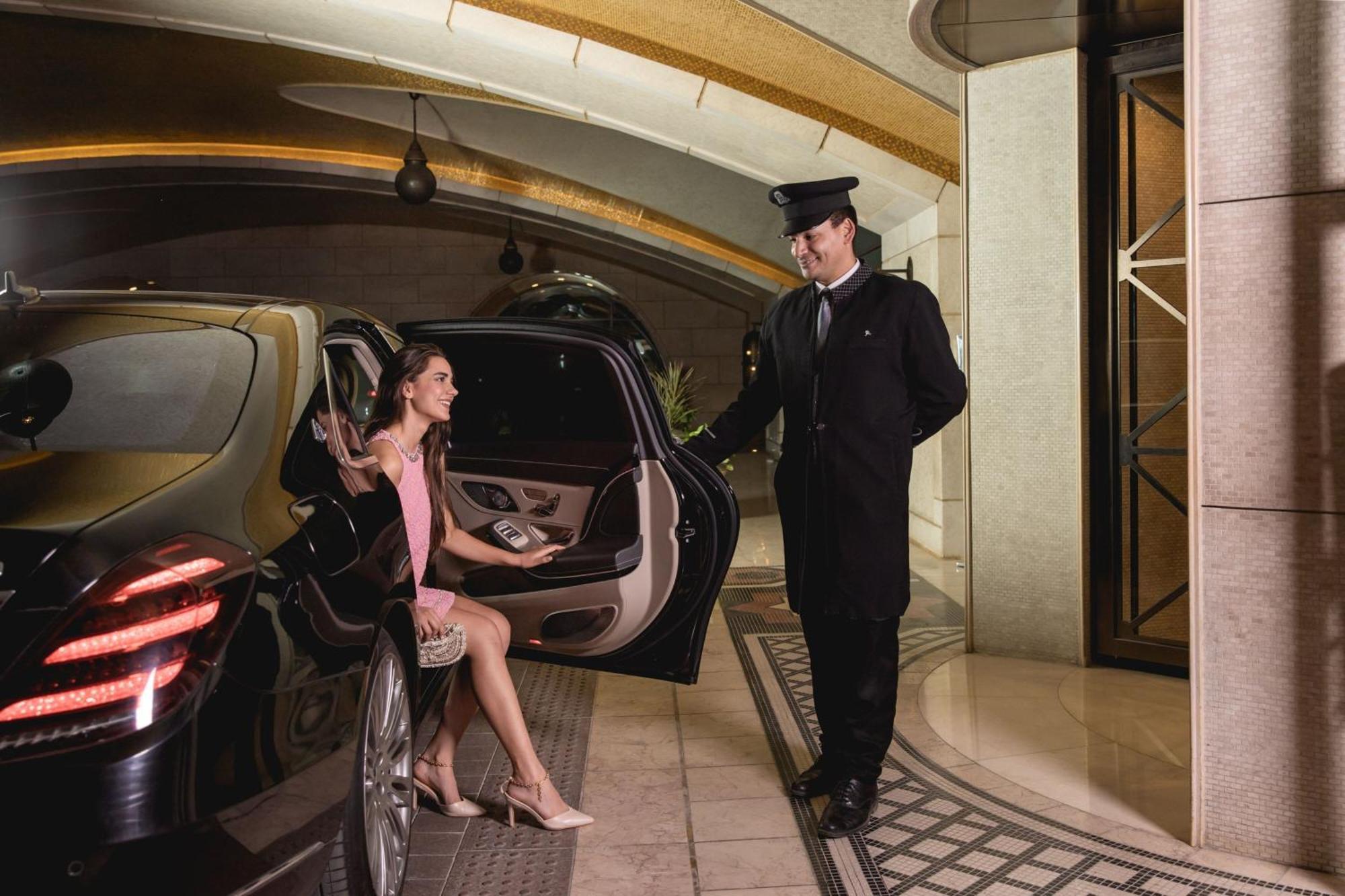 Hotel The St. Regis Il Cairo Esterno foto A chauffeur opening a car door for a passenger